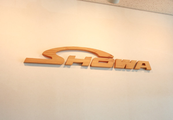 玄関の壁に貼ってある木製のロゴ